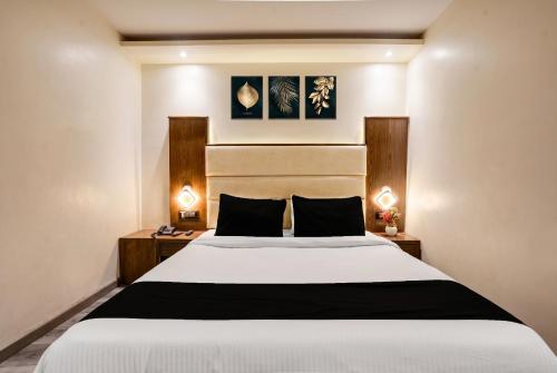 a bedroom with a white bed with two night stands at Collection O Andheri Near Western Express Highway in Mumbai