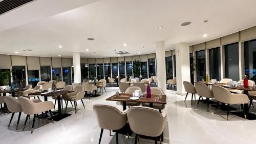 a restaurant with tables and chairs and windows at The Theme, Jaipur in Jaipur