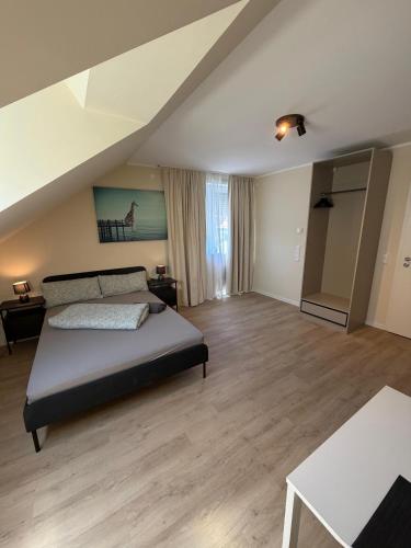 a large bedroom with a bed and wooden floors at NB14-1 Living in Weingarten (Karlsruhe)