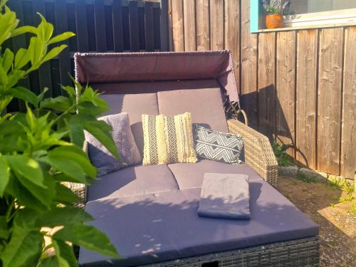 a wicker couch with pillows on a patio at Coastline Apartments in Fuhlendorf