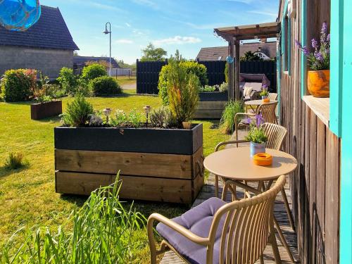 a patio with a table and chairs in a garden at Coastline Apartments in Fuhlendorf
