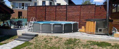 a hot tub in a yard next to a fence at Domki pod Beskidem in Jaworzynka