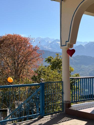 a balcony of a house with a view of the mountains at Tree house munsyari in Munsyari