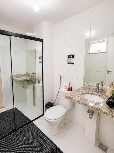 a white bathroom with a toilet and a sink at Ap Go travel in São Luís