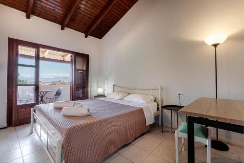 a bedroom with a bed and a table and a desk at Stay Easy Sidari Apartments in Sidari