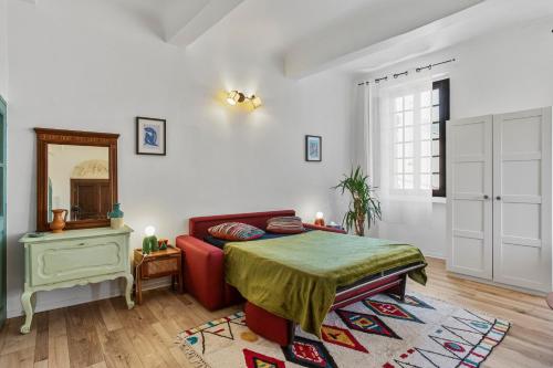 a bedroom with a bed and a mirror at Appartement Provençal in Cotignac