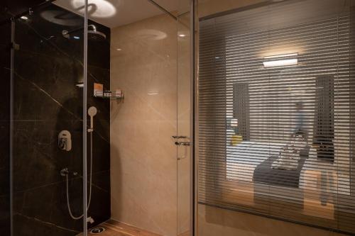 a shower with a glass door in a bathroom at Clubway Grand A Boutique Hotel Jorhat in Jorhāt