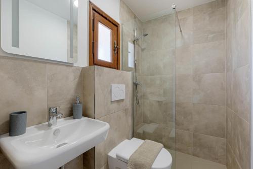 a bathroom with a sink and a toilet and a shower at Stay Easy Sidari Apartments in Sidari