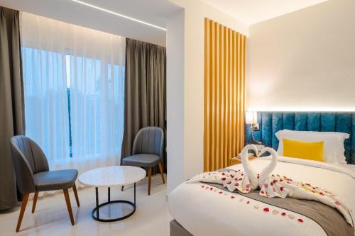 a hotel room with a bed and a table and chairs at Clubway Grand A Boutique Hotel Jorhat in Jorhāt
