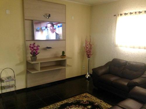 a living room with a couch and a flat screen tv at Hotel London in Araraquara