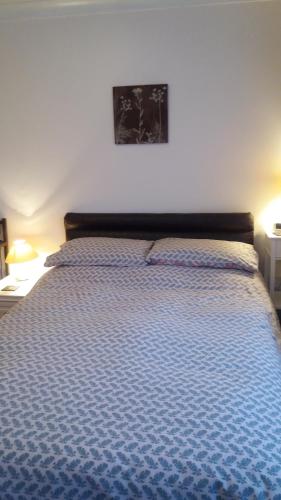 een slaapkamer met een bed met een blauw dekbed bij Orton Waterville Residence in Peterborough