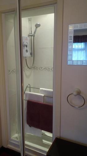 bagno con doccia e lavandino con asciugamani di Orton Waterville Residence a Peterborough