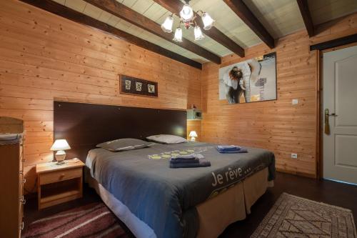 a bedroom with a bed in a wooden wall at Chalet des Charbonneux, nature in Le Ménil