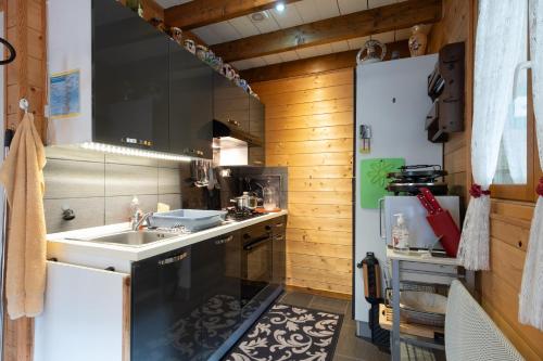 a small kitchen with a sink and a refrigerator at Chalet des Charbonneux, nature in Le Ménil