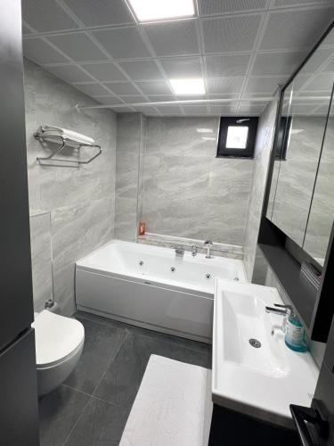 a bathroom with a tub and a toilet and a sink at Riviera Villa Kemer in Agva