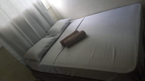 a white bed with a brown object sitting on it at Casa acogedora in Veracruz