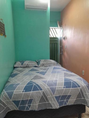 a bedroom with a bed with a blue and white quilt at Meu refúgio 01 in Belém