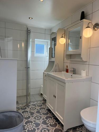 a white bathroom with a sink and a toilet at Exclusive Designer Cabin - Panoramic Mountain View in Vossevangen