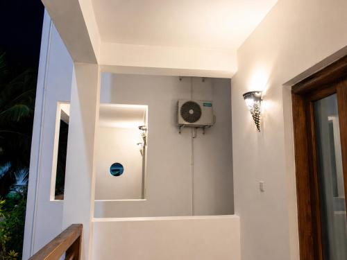 a bathroom with a shower and a fan on the wall at Jabali Bungalows Lodge in Paje