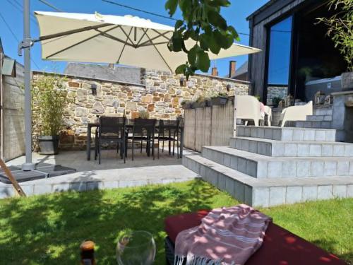 a patio with a table with a cake and an umbrella at 3 Waters Spa - Private Spa with Jacuzzi, Sauna & Hammam in Winenne