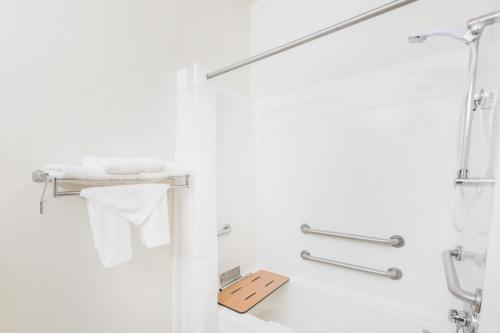 a white bathroom with a shower and a sink at Super 8 by Wyndham Holton in Holton
