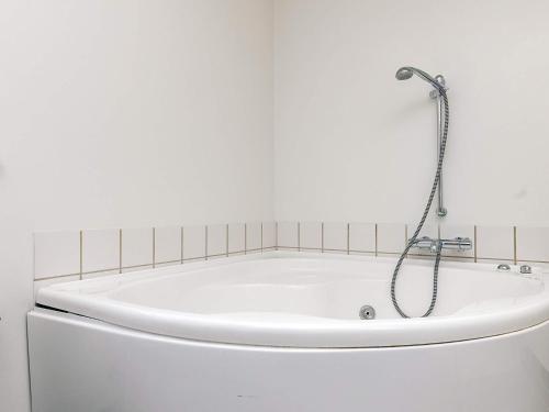 a white bath tub with a shower in a bathroom at 5 star holiday home in Nysted in Nysted