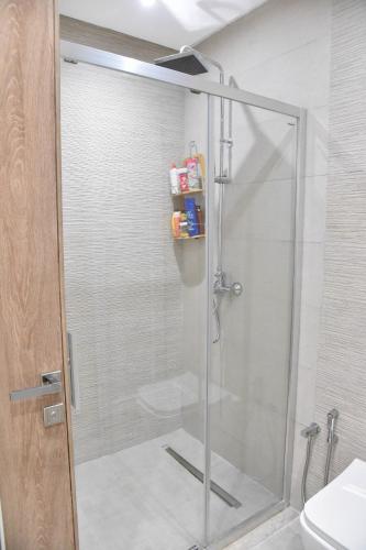 a shower with a glass door in a bathroom at L'escapade in Sousse