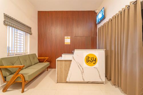 a waiting room with a couch and a sign at Itsy Hotels Snowdrop in Coimbatore