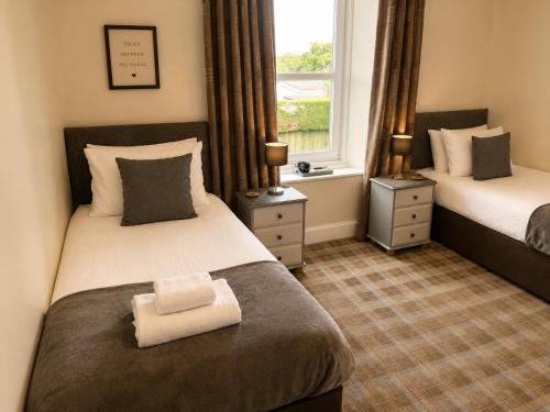 a hotel room with two beds and a window at The Anglers Inn in Guildtown