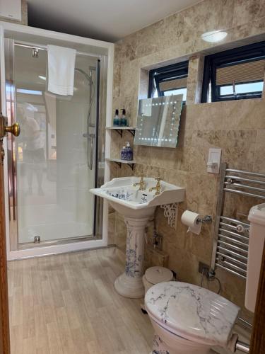 a bathroom with a sink and a shower and a toilet at Oakwood Bed and Breakfast Heathrow in Hillingdon