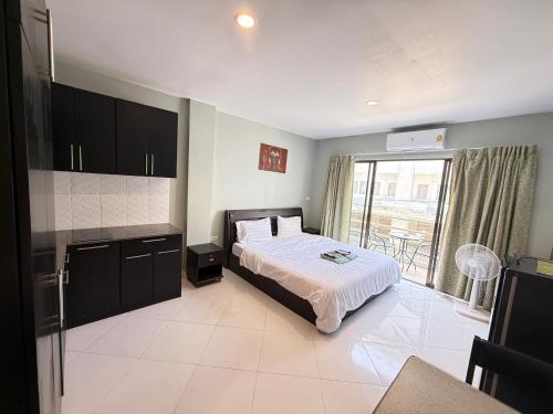 a bedroom with a bed and a large window at Emerald hotel in Jomtien Beach