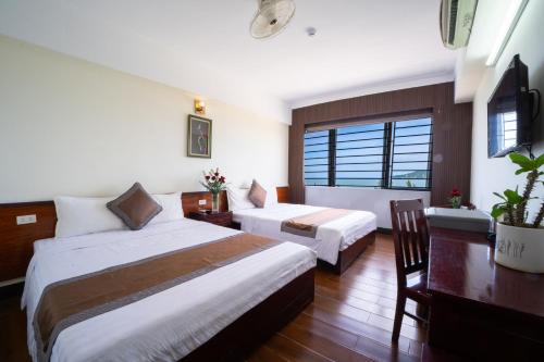 a hotel room with two beds and a desk at SAMMY Hotel - Khách sạn SAMMY in Giáp Vinh Yên