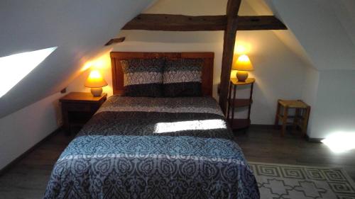 um quarto com uma cama num sótão com 2 candeeiros em Chez Tripp em Talmontiers