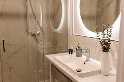a bathroom with a sink and a shower with a mirror at GOLDEN HAUS Opole - Royal Blue & Royal Green in Opole