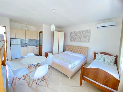 a bedroom with a bed and a table and chairs at APARTAMENT RADHIME in Vlorë