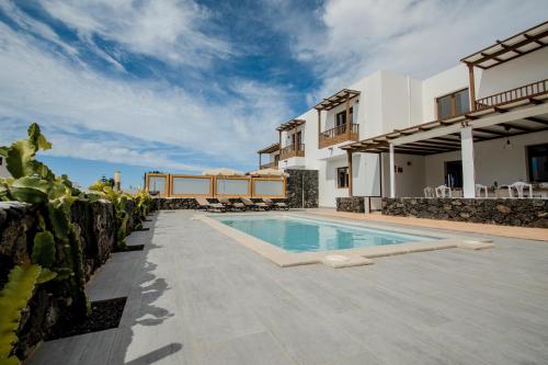 a villa with a swimming pool and a house at Villa Barrilla by Villalize in Tinajo