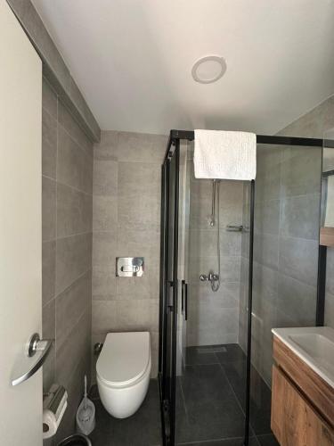 ein Badezimmer mit Dusche, Toilette und Waschbecken in der Unterkunft Uraz Hotel in Kemer
