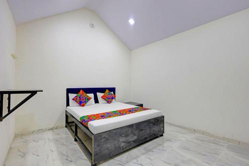 a bedroom with a bed in a white room at FabHotel Mahi Resort in Aurangabad