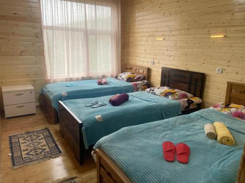 a room with three beds with red shoes on them at Guest house River side in Adishi