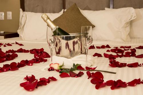 a bottle of champagne on a bed with red roses at Suites Lerma 205 in Mexico City