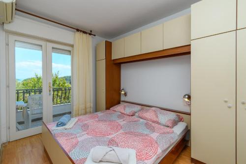 a bedroom with a bed and a balcony at Apartments Verdea in Kampor