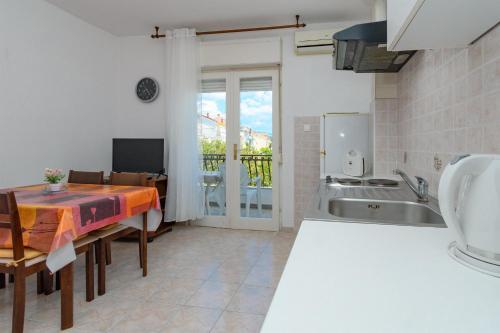 a kitchen with a table and a sink at Apartments Verdea in Kampor
