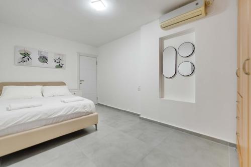 a bedroom with a bed and a white wall at Spacious Luxury Beach Getaway by Torohome in Ashdod