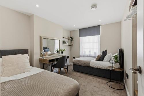 a bedroom with two beds and a desk in it at Chic City Apartment in Wakefield