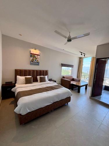 a large bedroom with a large bed and a couch at Rumuk Boutique Resort - Offbeat escape in Dhanaulti