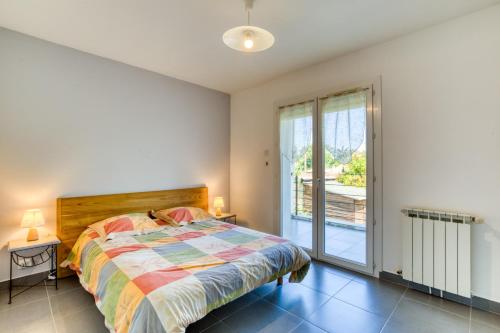 a bedroom with a bed and a large window at Gîte Gignac Vallée De L'hérault in Gignac