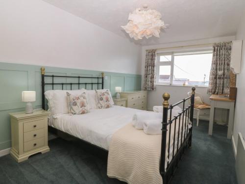 a bedroom with a bed and a window at Wingelock in Rhosneigr