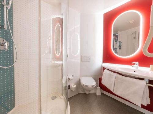 a bathroom with a toilet and a sink and a mirror at ibis Genève Centre Nations in Geneva