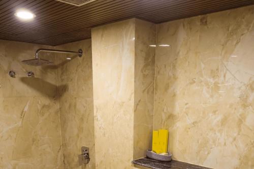 a bathroom with a shower with a stone wall at Briddhishree Palace in Guwahati