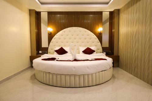 a bedroom with a large bed with a large headboard at Briddhishree Palace in Guwahati